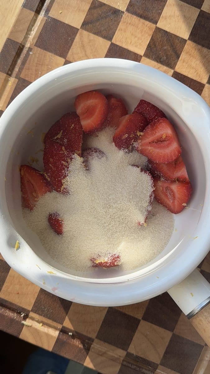 Strawberries, sugar, and lemon zest in a saucepan.