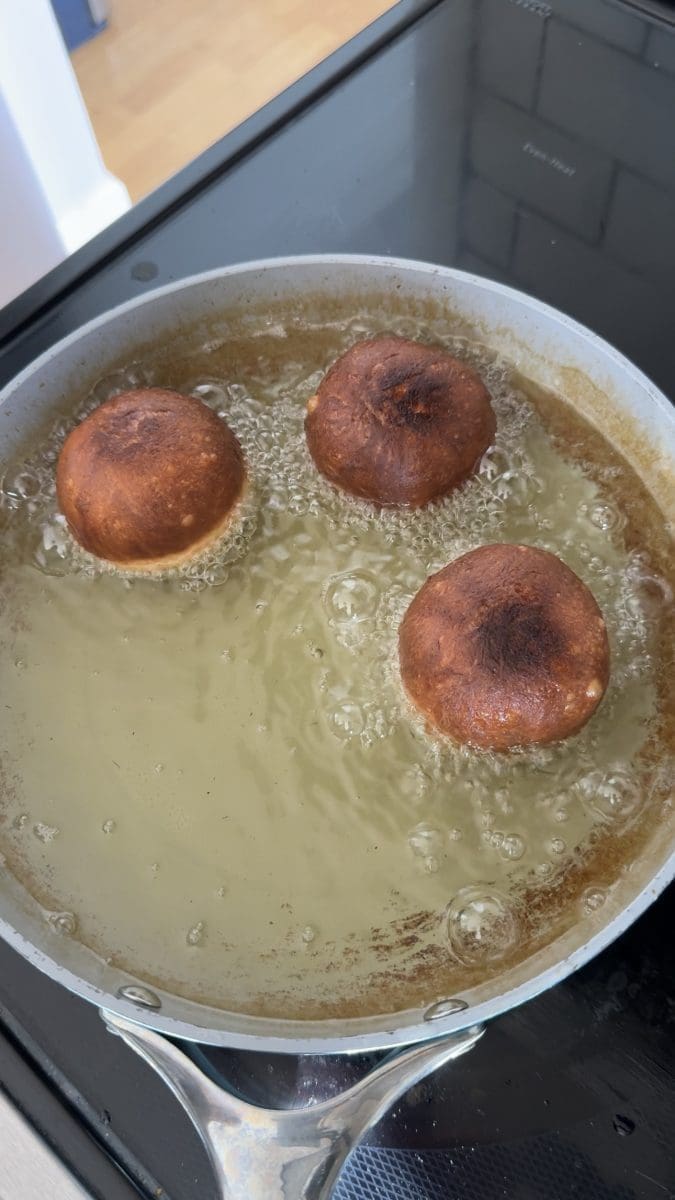 Frying the donuts on the stove.