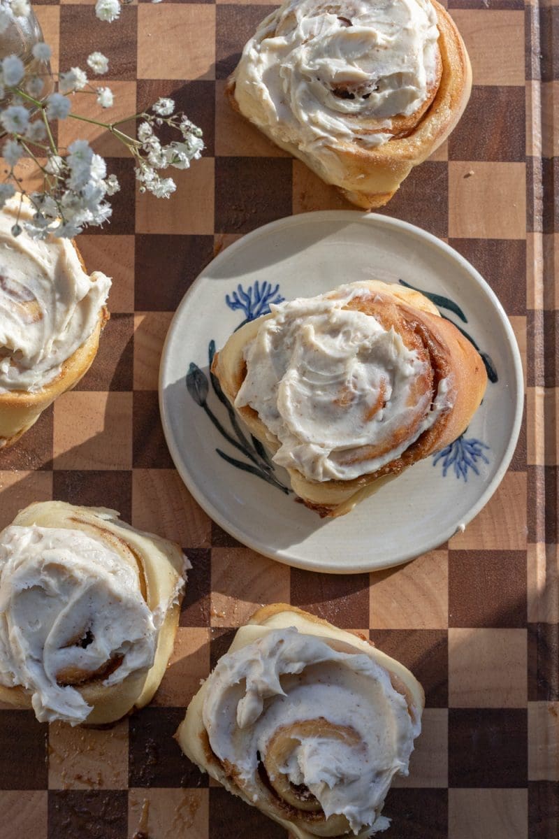 Small batch cinnamon rolls spread out on a cutting board.