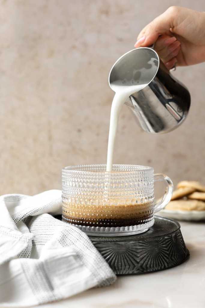 pouring the steamed and frothed milk into the cup.