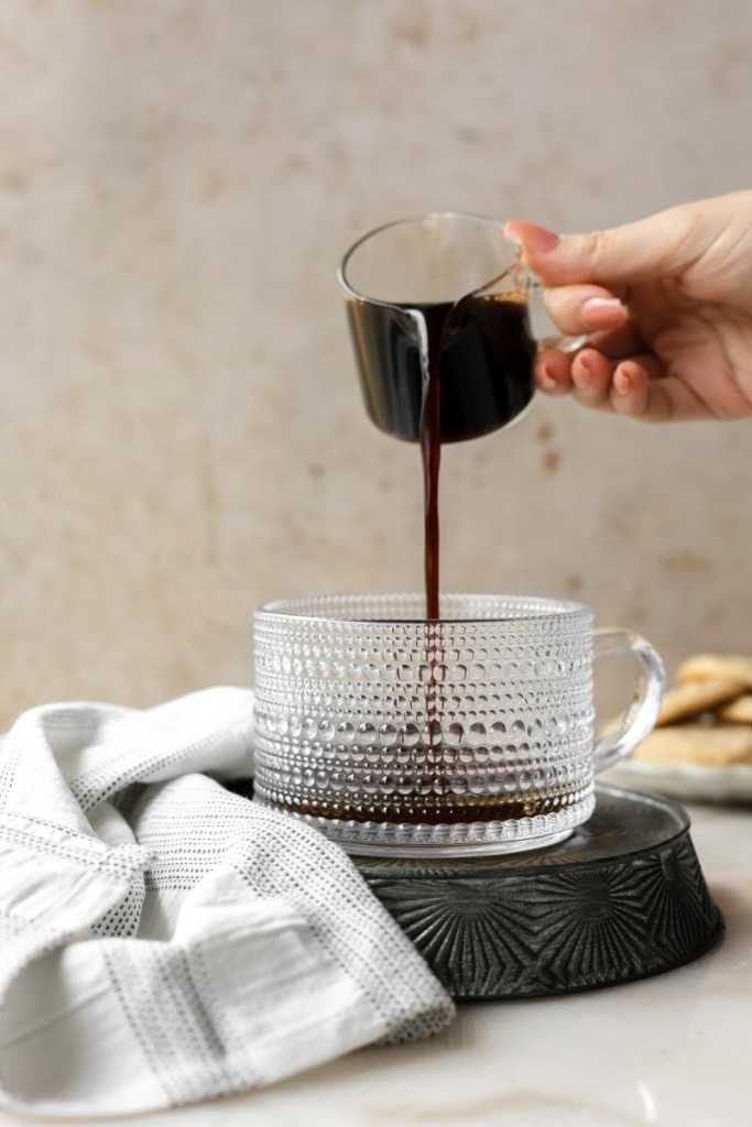 pouring espresso into the cup.