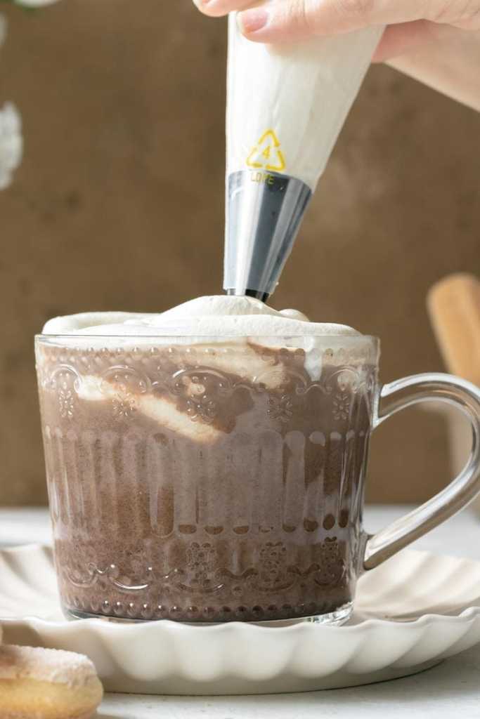 Piping the mascarpone whipped cream on top of the drink