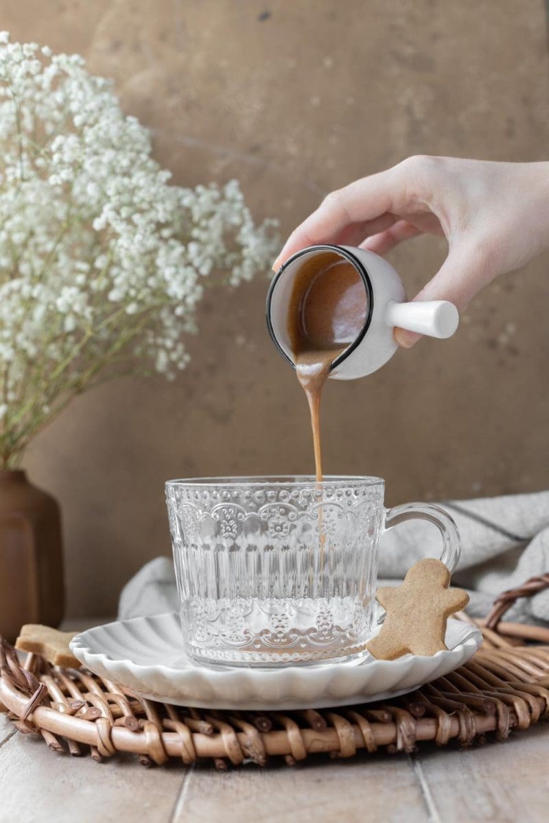 Pouring gingerbread white chocolate sauce into the cup.