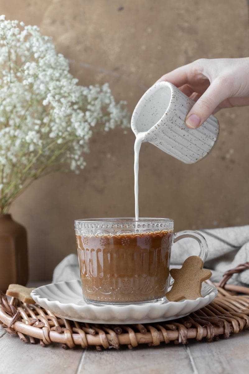 Pouring milk into the cup.
