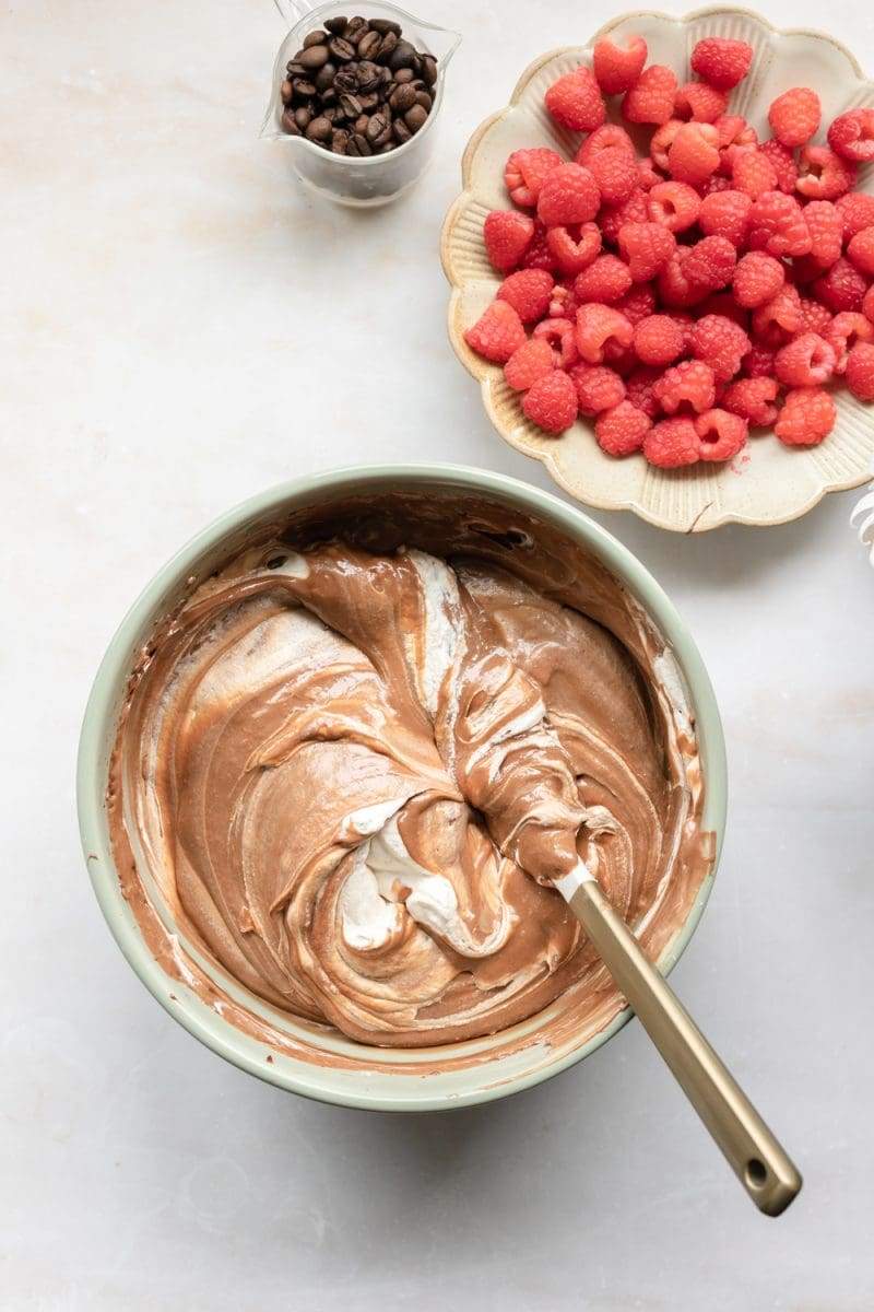 Folding whipped cream into the pie filling.