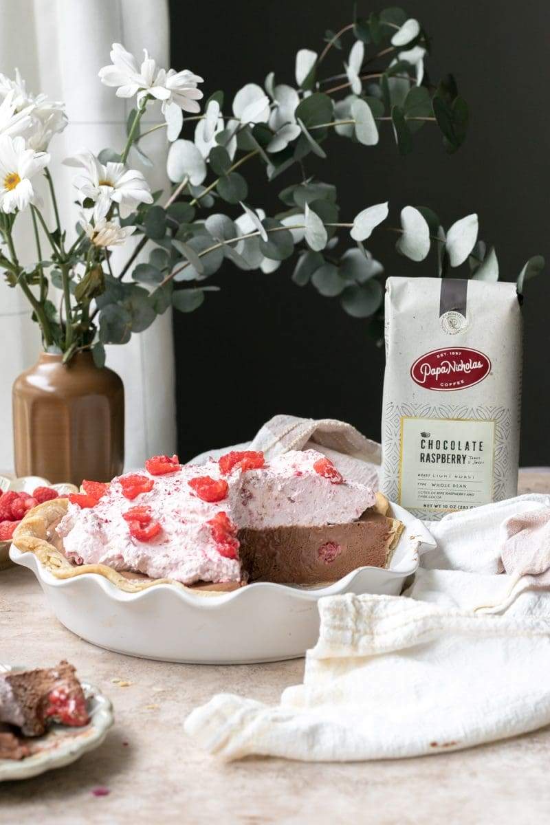 The raspberry mocha french silk pie next to a bag of PapaNicholas Coffee.