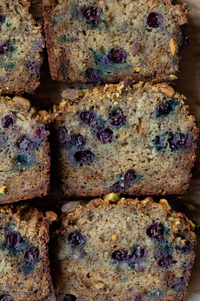 Slices of the blueberry banana bread laying flat right next to each other.