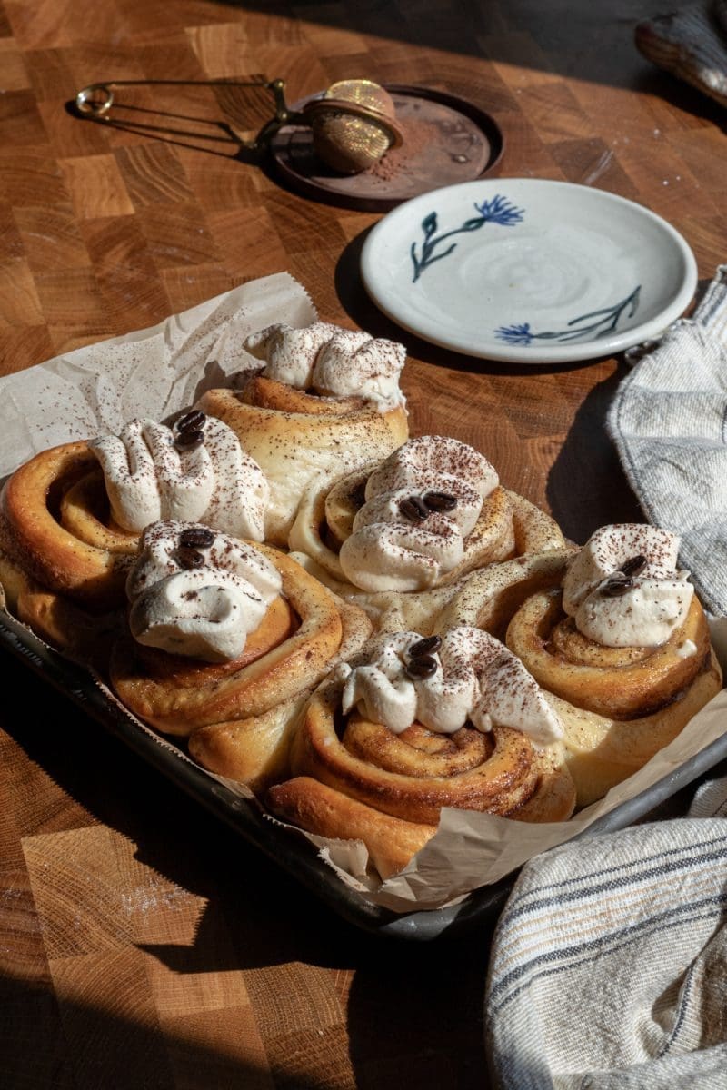 The tiramisu cinnamon rolls frosted in a pan.