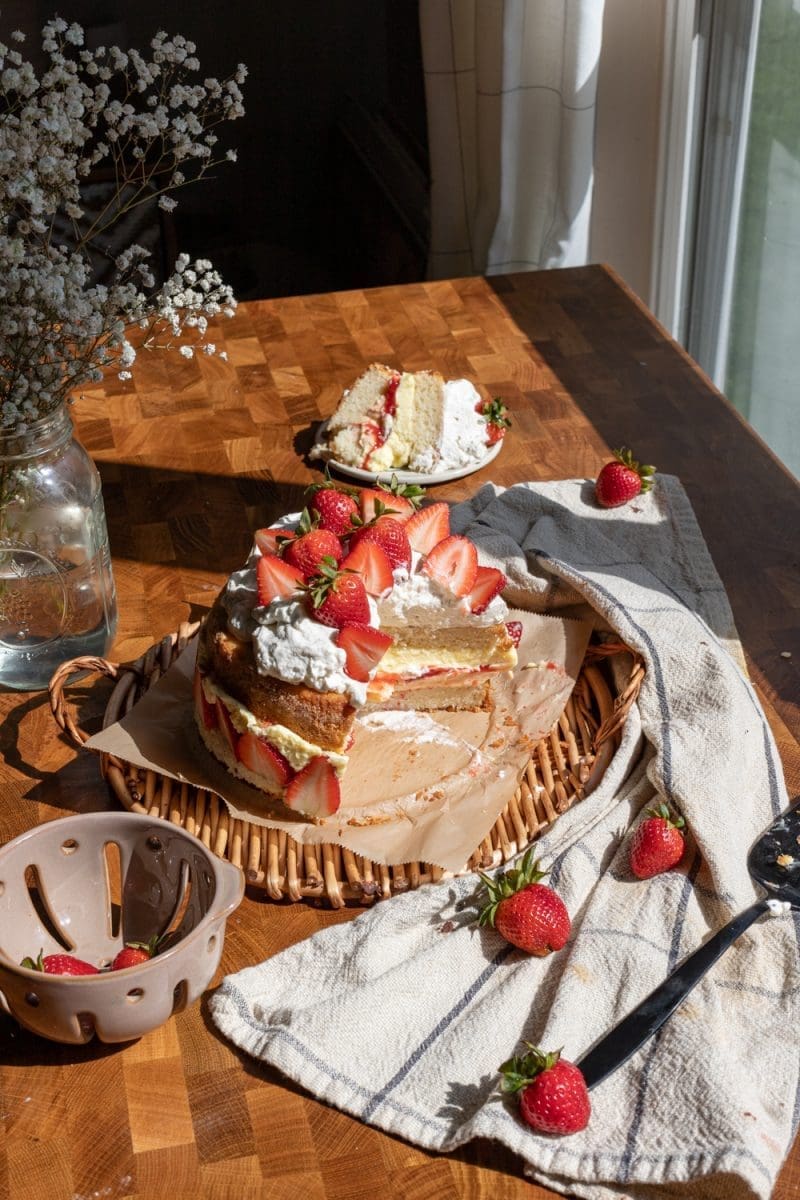 Angled view of the sliced strawberries and cream cake.