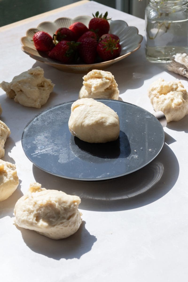 Dough pieces surrounding a kitchen scale.