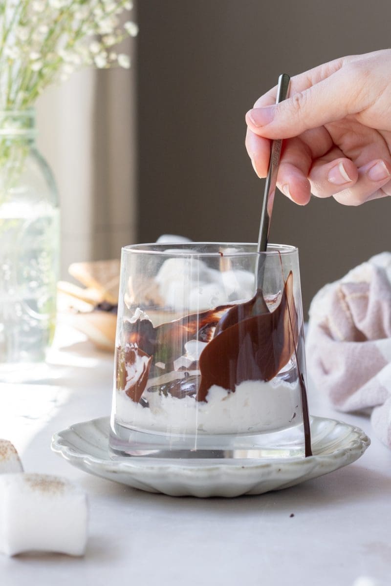 Lining the inside of the cup with chocolate sauce.