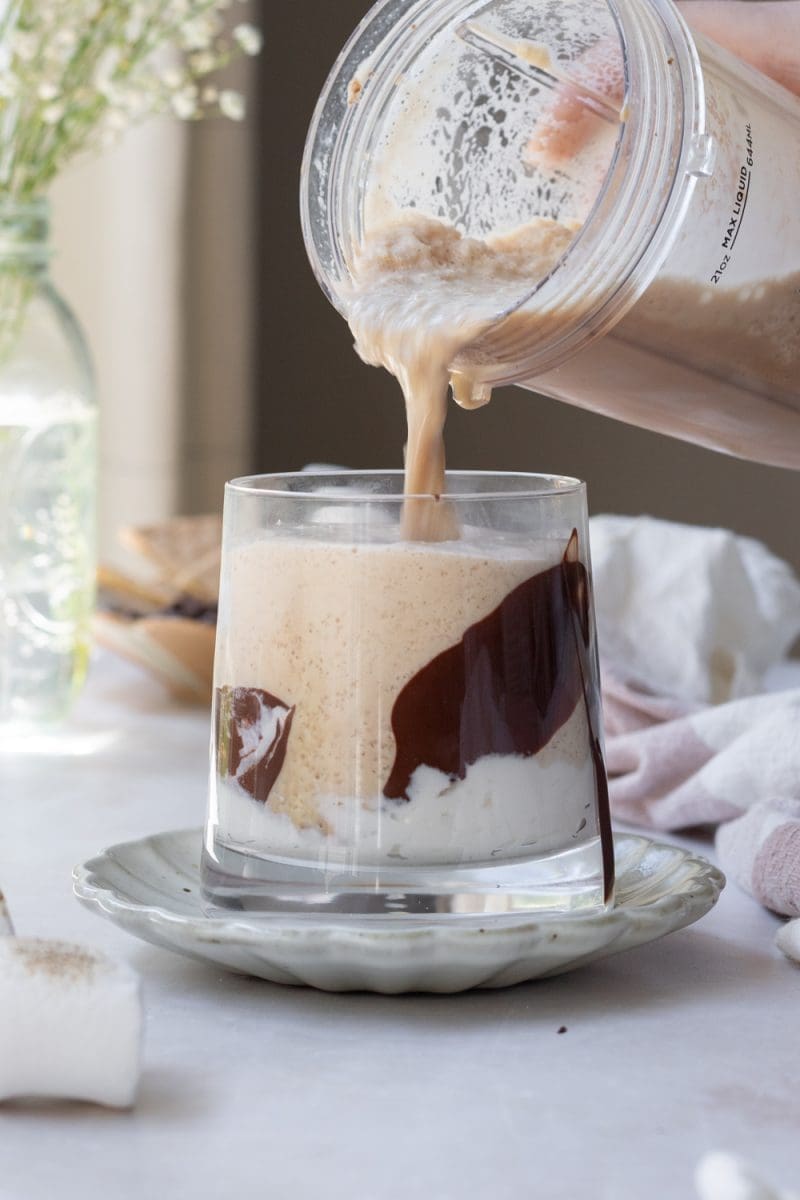 Pouring the frappuccino into the cup.