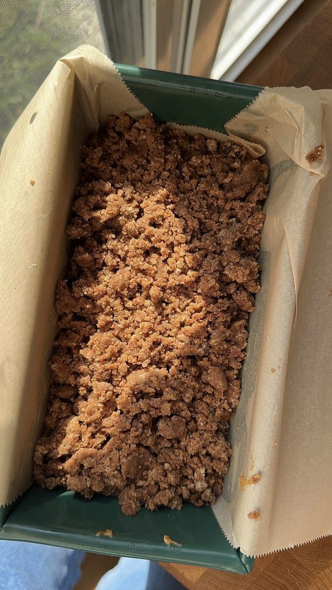 The pumpkin coffee cake and streusel layered together in a loaf pan.