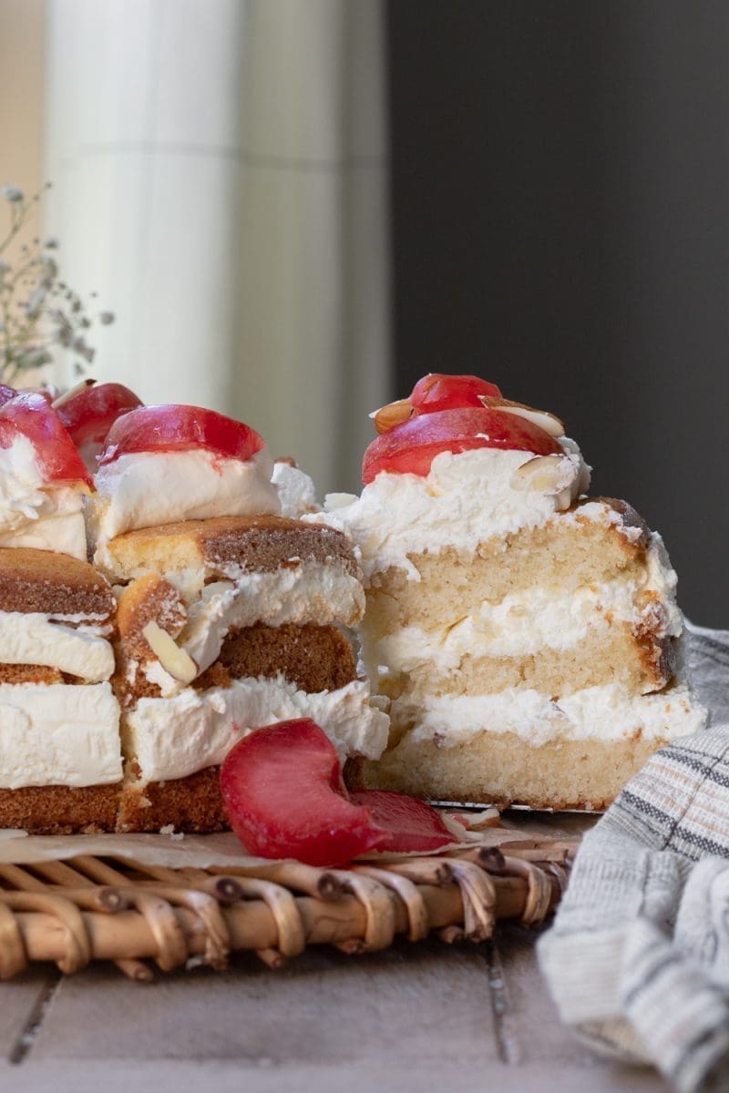 A slice of the almond cream cake being pulled away from the whole cake