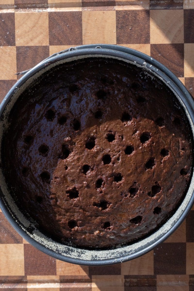 Holes poked in to the top of the chocolate cake.