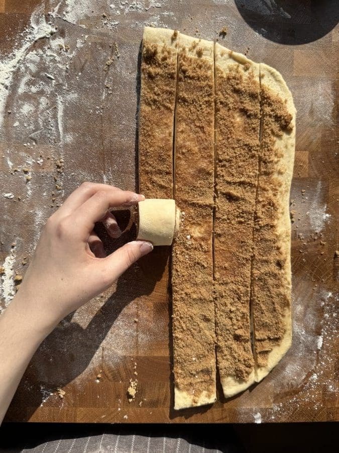 Rolling up the cinnamon rolls.