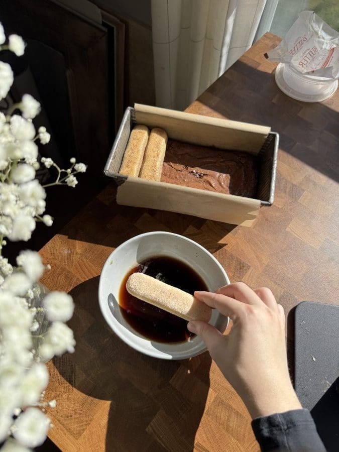 Dipping ladyfingers into espresso.