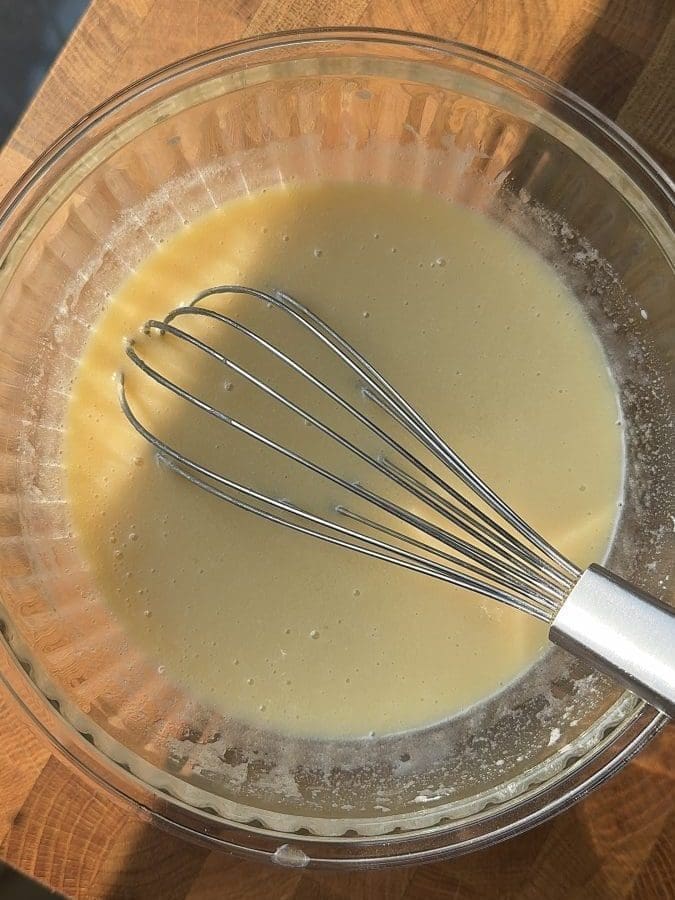 Wet ingredients whisked together in a mixing bowl.