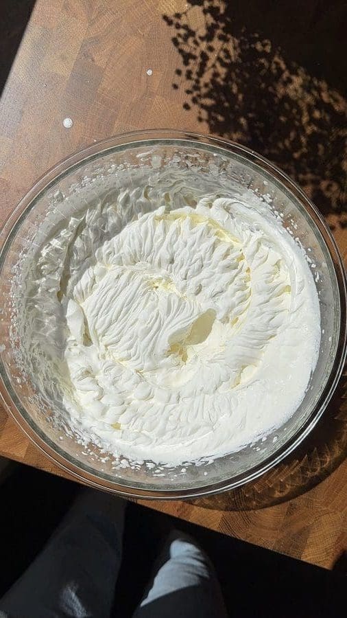 Whipped cream in a large mixing bowl