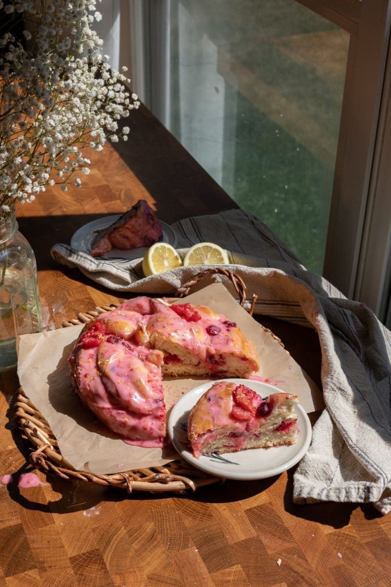 The giant lemon raspberry brioche bun cut up on a serving tray.