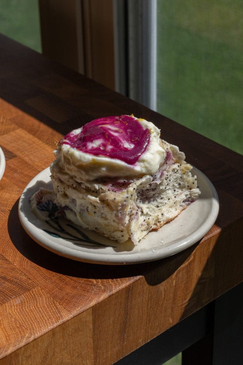 Close up of one of the blueberry lemon poppy seed rolls on a plate.
