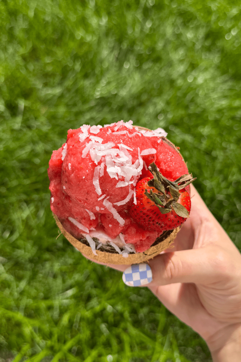 Overhead view of the no-churn strawberry coconut sorbet in a coconut.