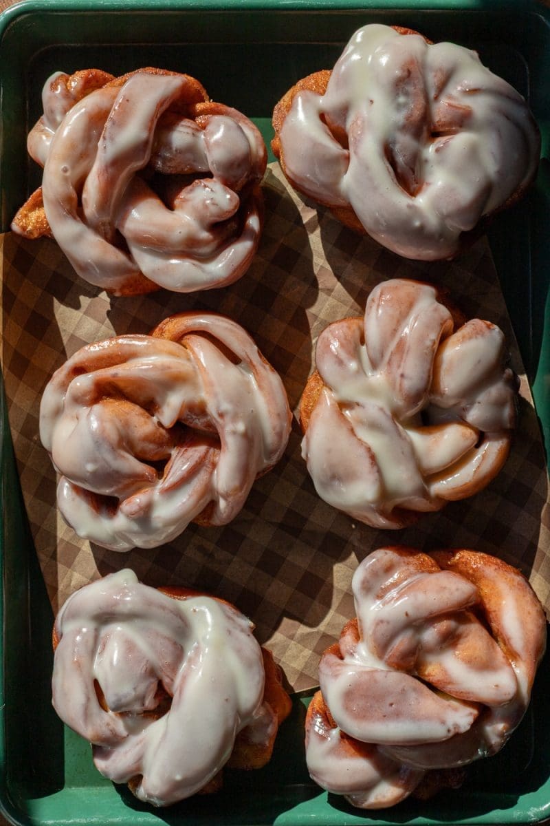 The cinnamon roll donuts on a baking sheet.
