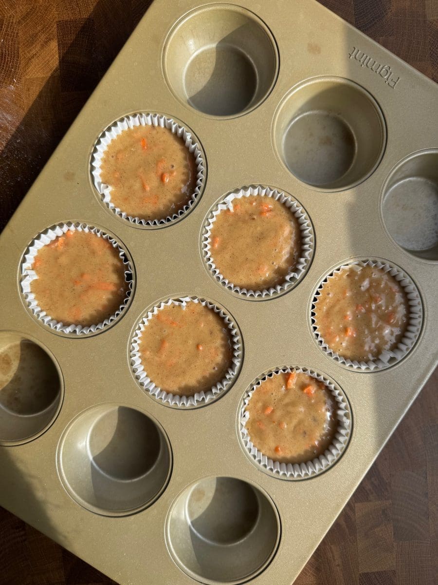 The cupcake batter divided up between six parchment liners