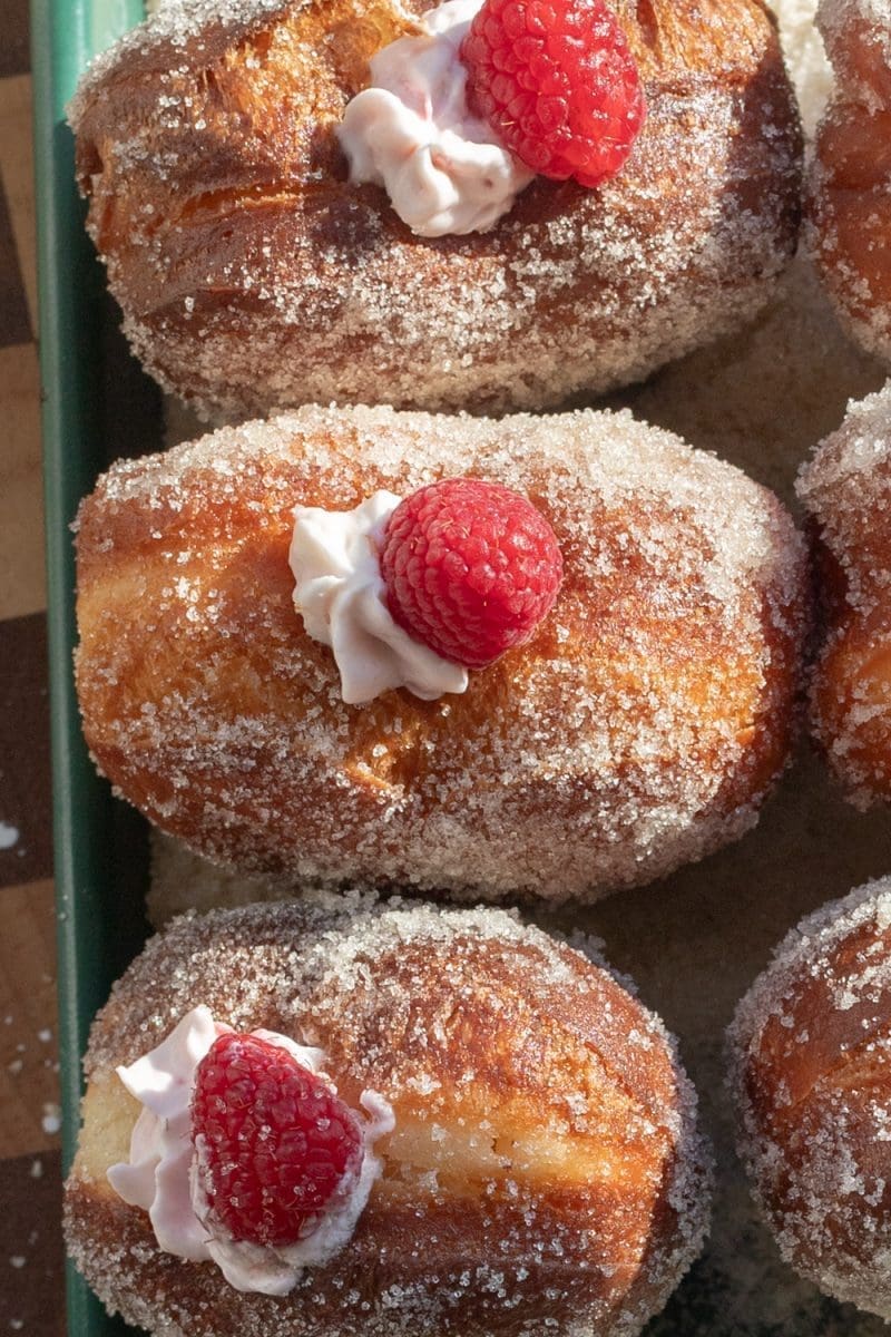 Close up of the tops of the filled raspberry cheesecake heart donuts.