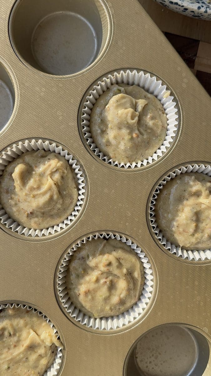 The cupcake batter divided between six parchment liners.