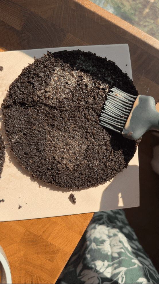 Brushing the cake with the latte mixture.